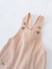 Beige corduroy overalls on a light gray background