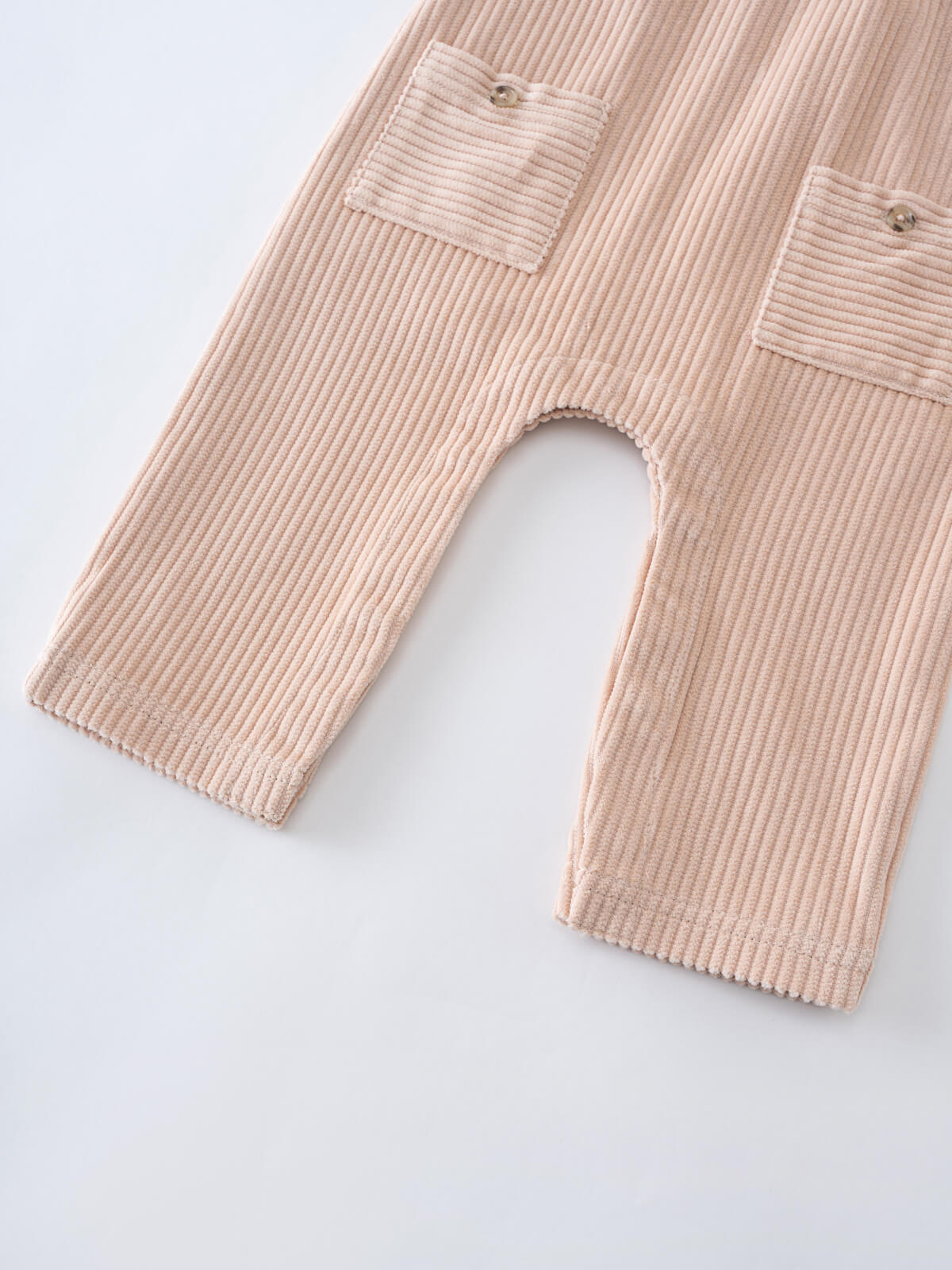 Beige corduroy overalls on white background