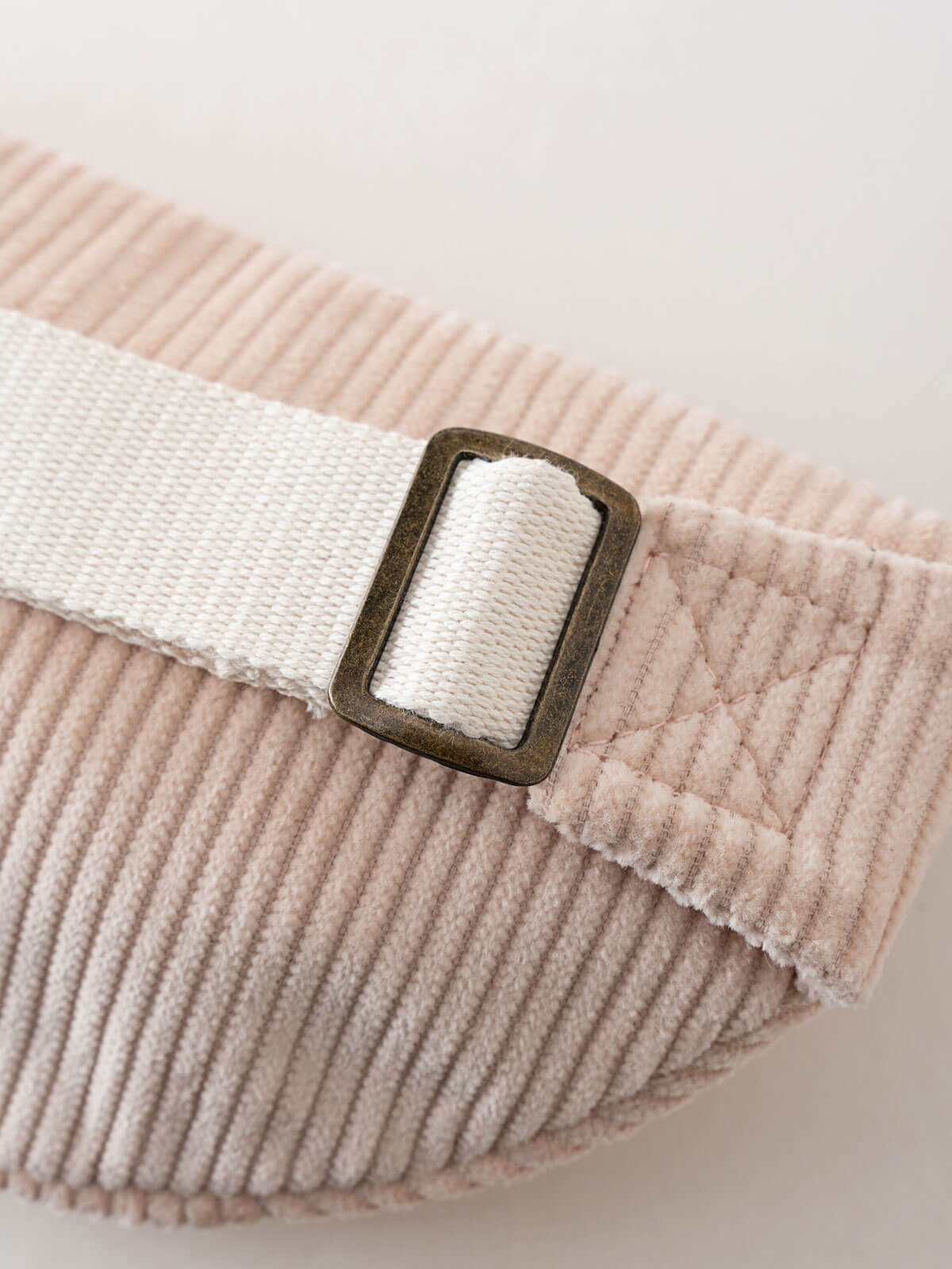 Pink corduroy waist bag with a white strap and brass buckle on a light background Crossbody Bag - Dove Girls