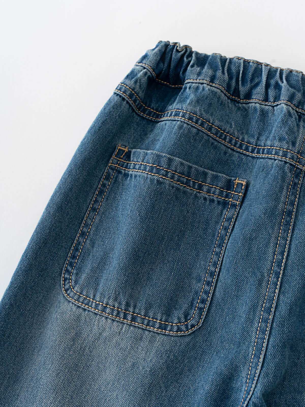 Close-up of blue denim pants showing back pocket with stitching detail Denim Pants - Blue Denim Girls and Boys