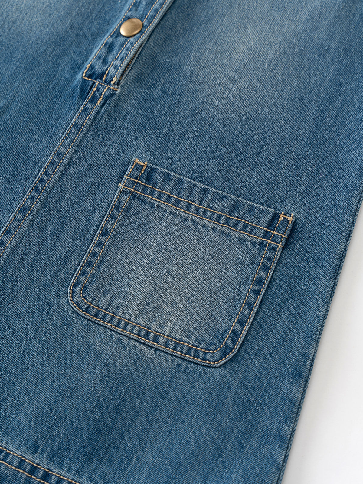 Close-up of a blue denim pocket on a jacket Denim Pinafore Dress - Blue Denim Girls