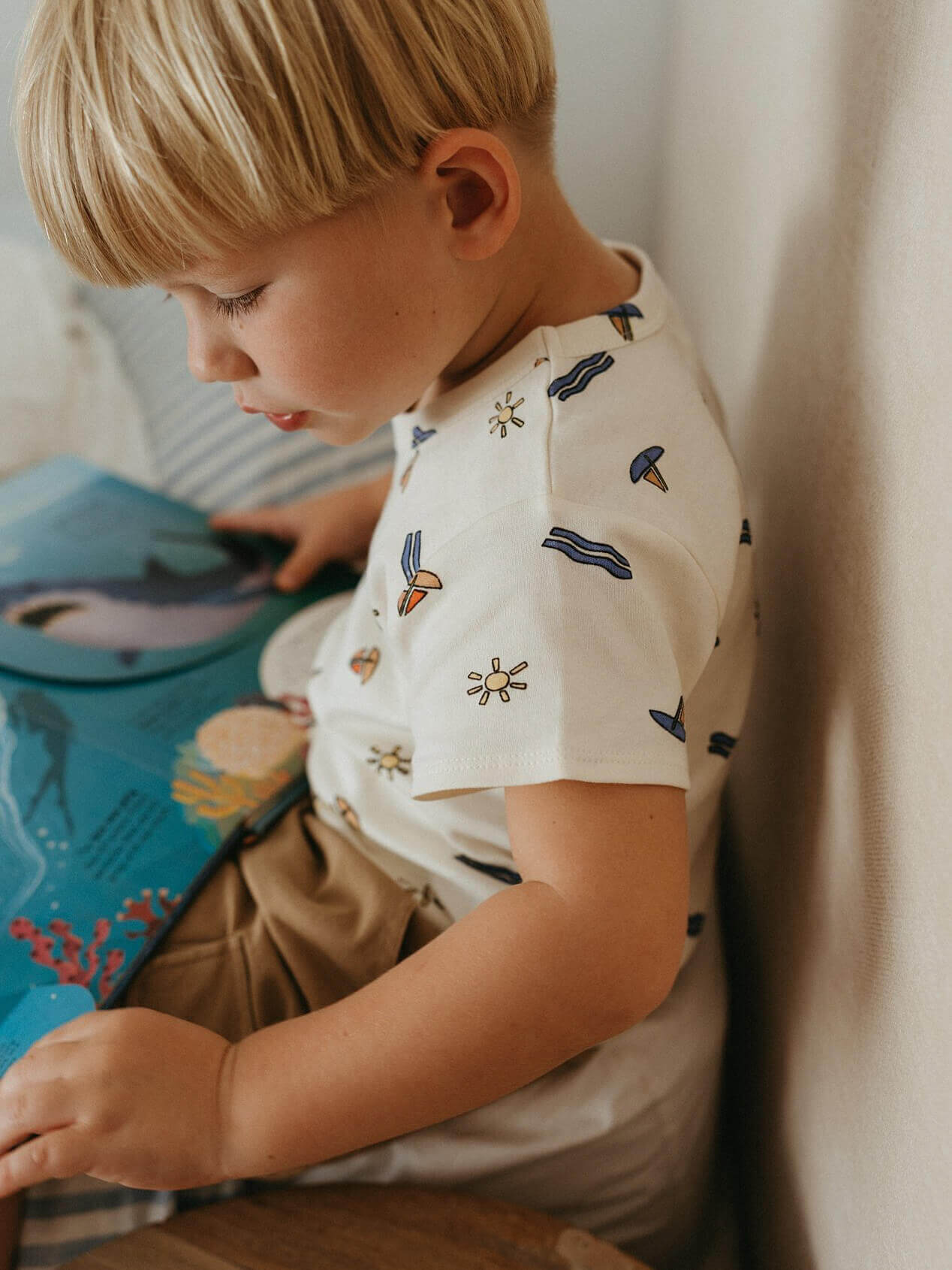 Child reading a book with a soft, warm background