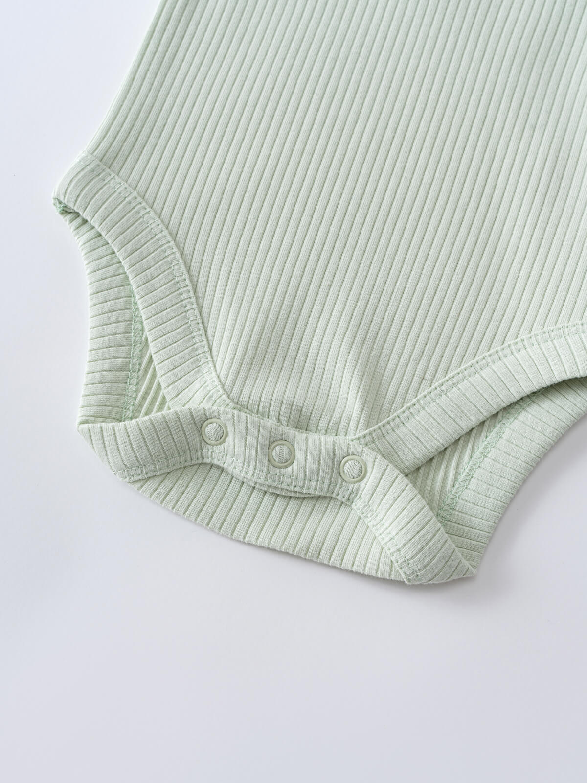 Close-up of a light green ribbed bodysuit with snap buttons at the crotch Henley Short Sleeve Bodysuit - Matcha Baby boy