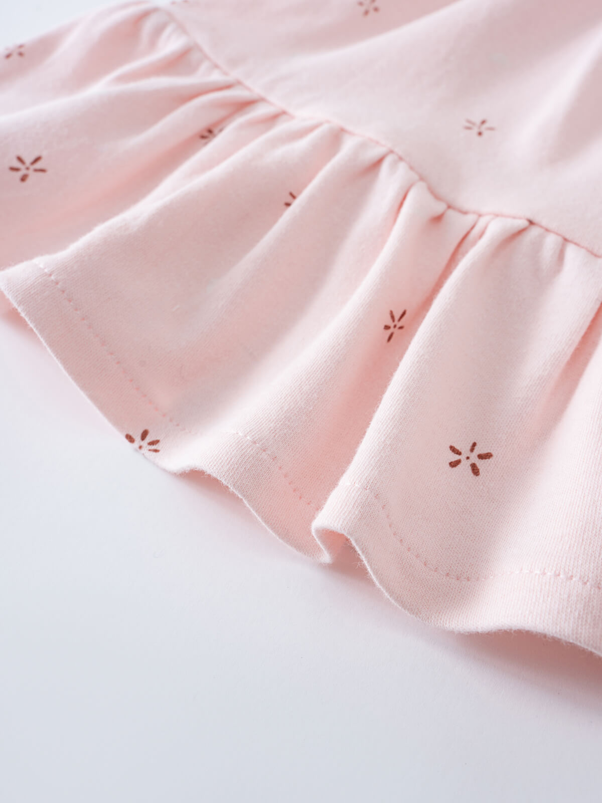 Close-up of a pale pink fabric ruffle with small embroidered floral details Jersey Skirt - Spring Love Girls