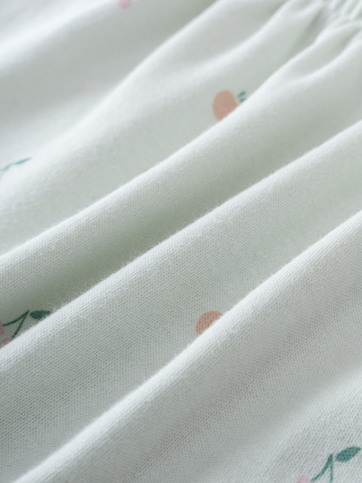 Close-up of white fabric with small floral print in pink and green Jersey Skirt - Summer Fruits Girls