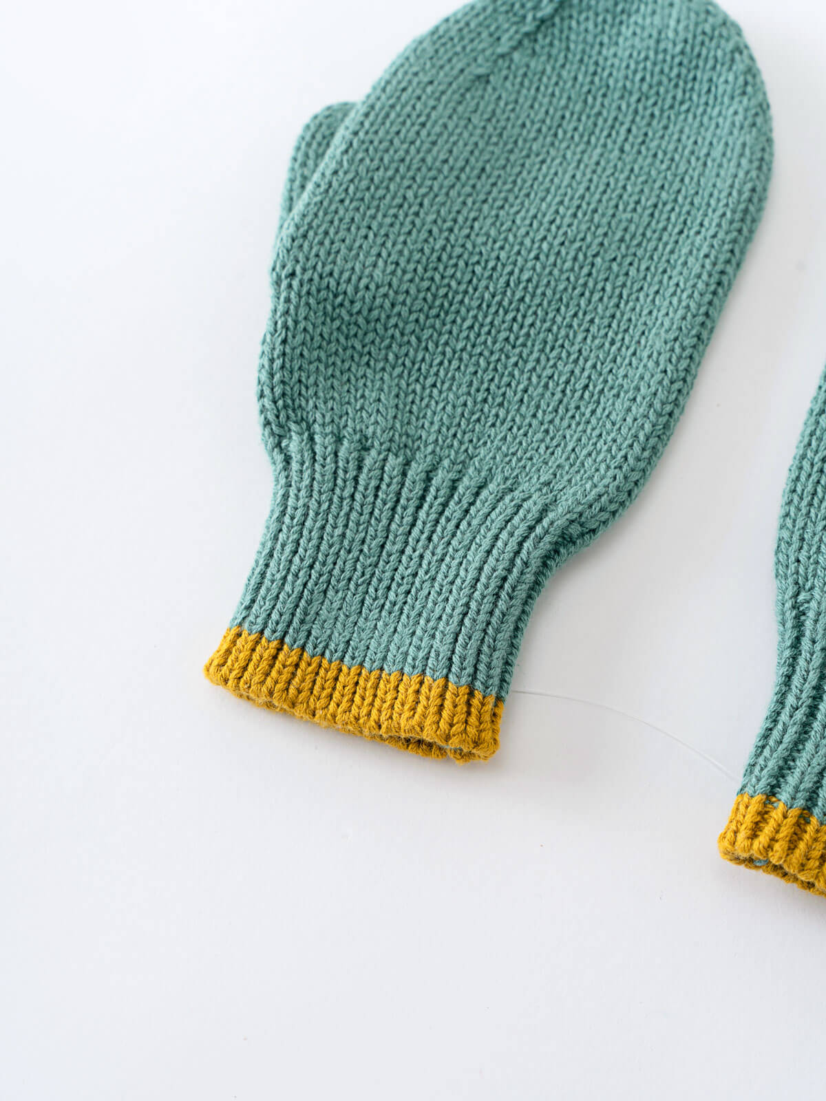 Knitted teal mittens with yellow cuffs on a white background Knit Mittens - Balsam Boys