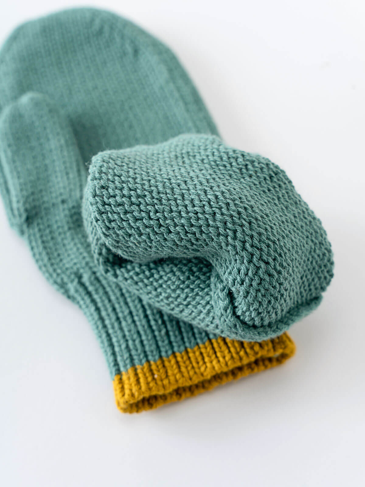 Pair of teal and mustard yellow mittens on a white background Knit Mittens - Balsam Boys