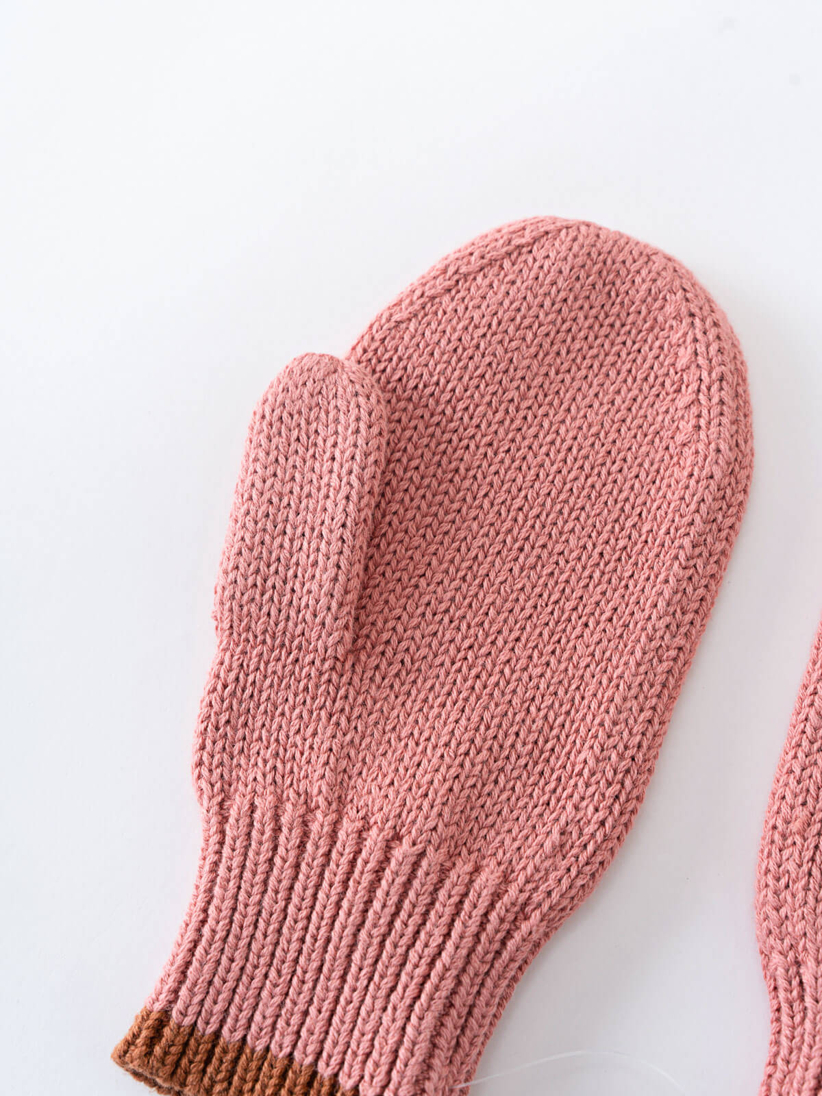 Pink knitted mitten on a white background Knit Mittens - Rosehip Girls