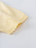 Close-up of pale yellow knit garment with ribbed cuffs and decorative stitching Knit Tee - Sun Soaked Girls