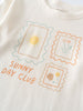 Close-up of a cream-colored shirt with three postage stamp graphics and text Long Sleeve Tee - Sunny Club Day Girls