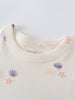 Close-up of cream-colored garment with purple shell and coral starfish pattern Lottie Short Sleeve Dress - Beach Shells Girls
