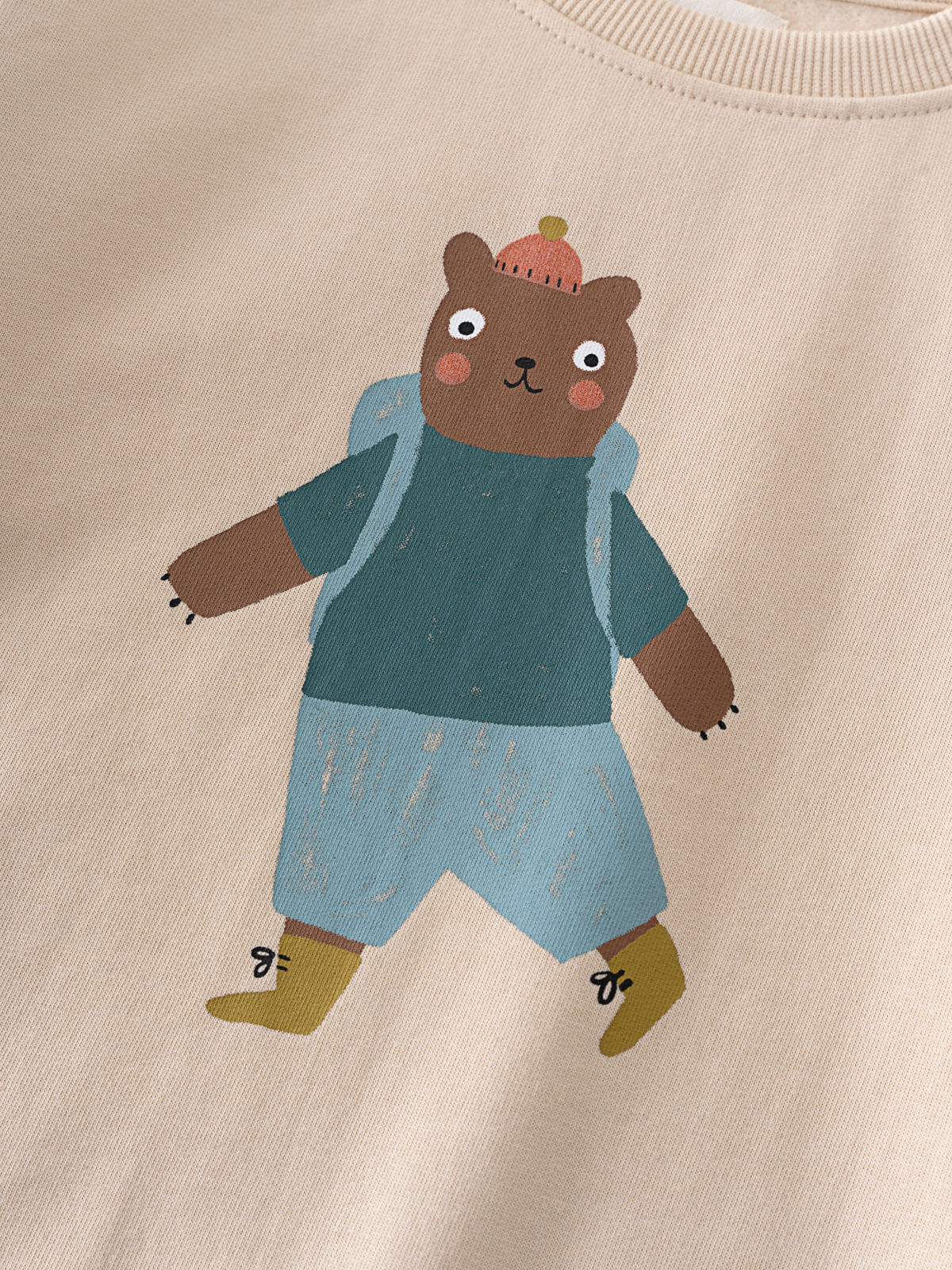 Close-up of beige sweatshirt with bear wearing blue outfit and beanie print Feature Print Sweatshirt - Hiking Bear Baby boy