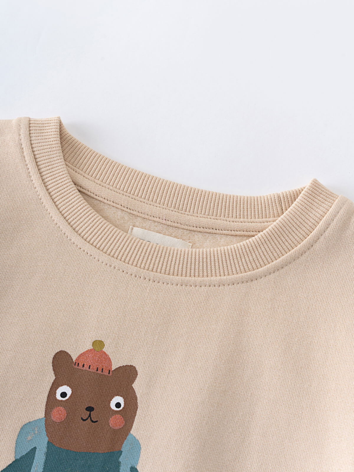 Close-up of beige sweatshirt neckline with bear illustration wearing blue jacket Feature Print Sweatshirt - Hiking Bear Baby boy