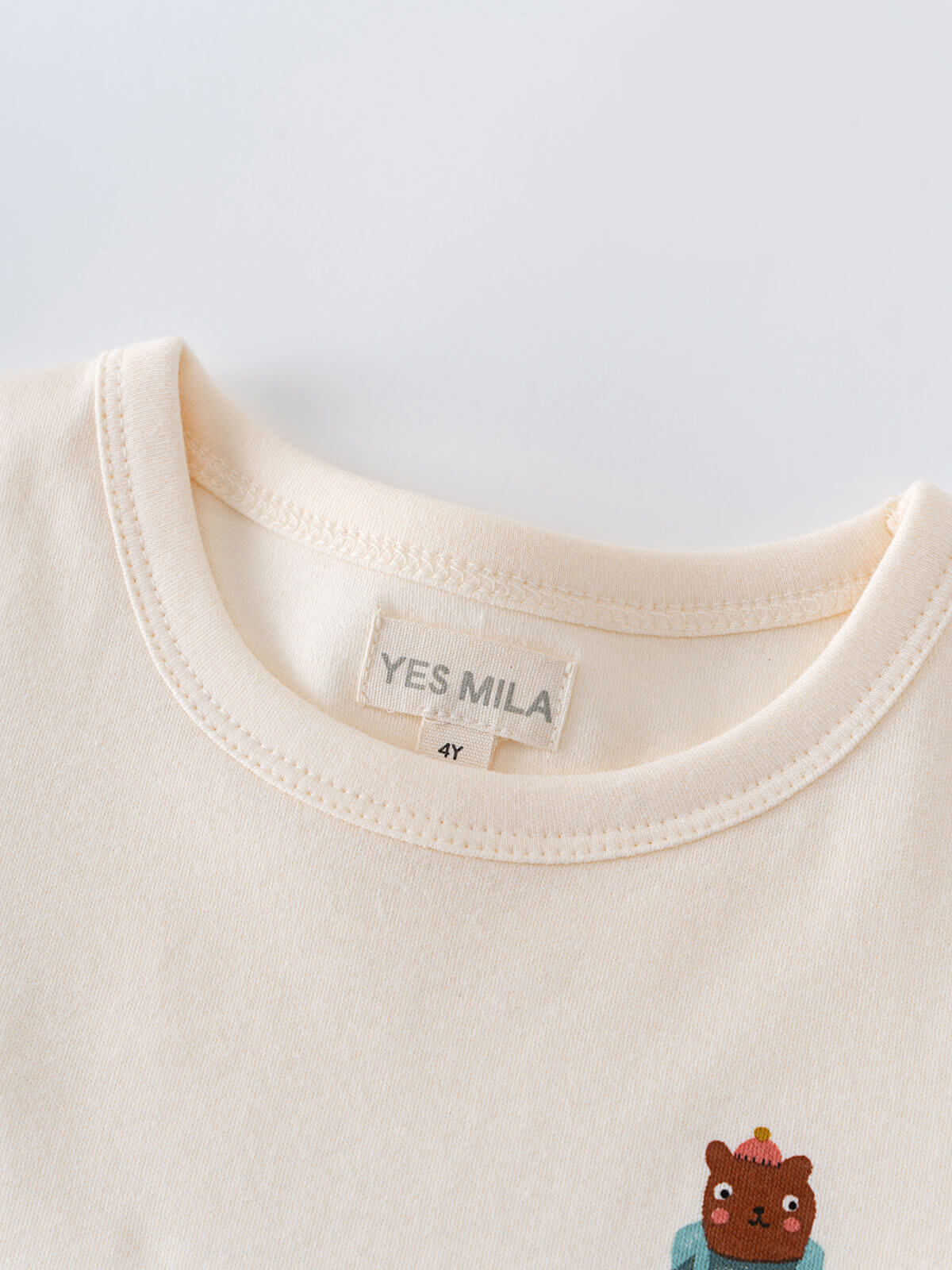 Close-up of cream colored t-shirt collar with embroidered bear detail Feature Print Short Sleeve Tee - Hiking Bear Boys