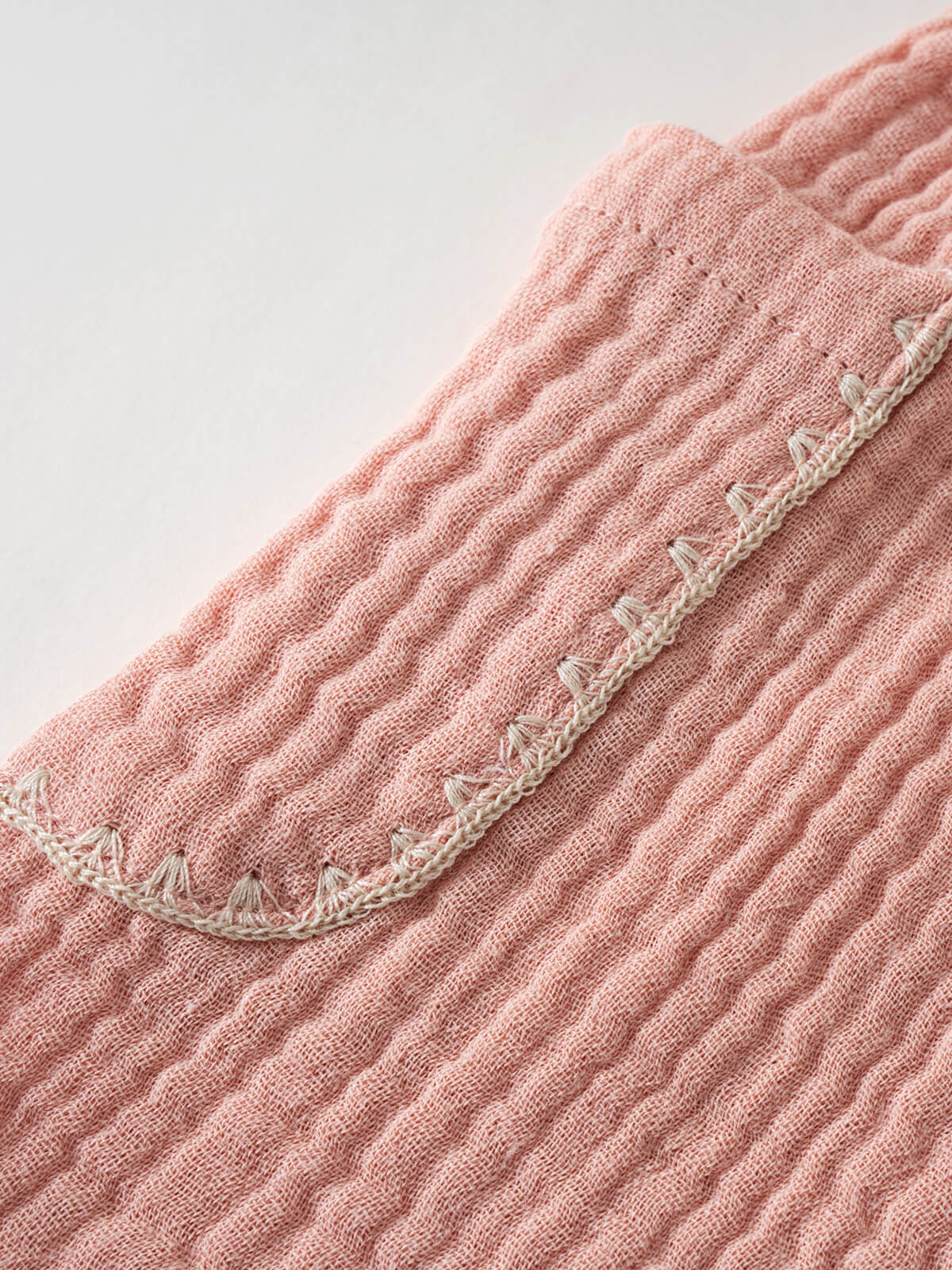Close-up of pink textured fabric shorts with cream crochet trim detail Muslin Shorts - Toasted Peach Girls