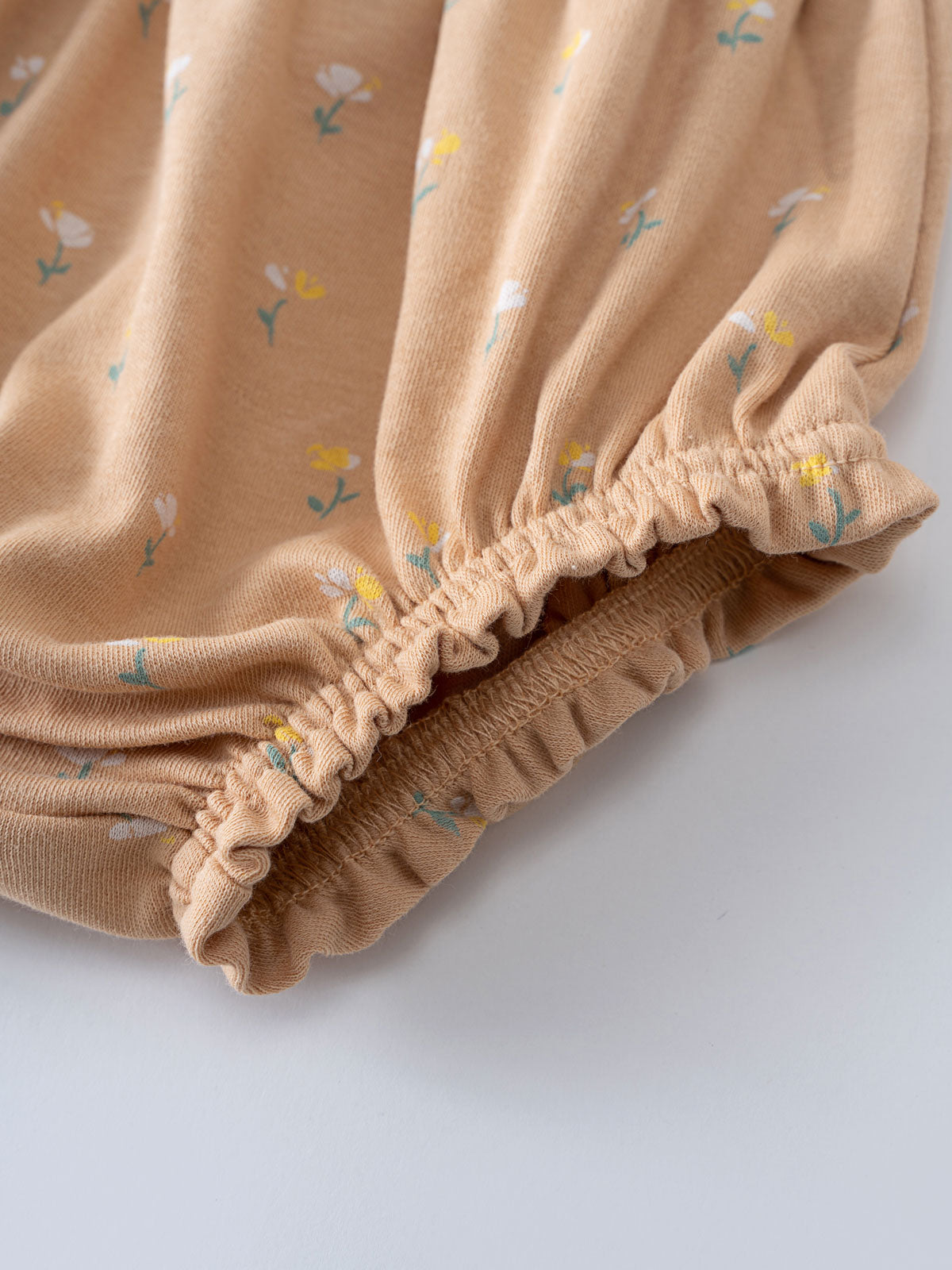 Close-up of beige fabric bloomers with small floral print and elastic gathering Printed Bloomers - Floral Bloom Baby girl