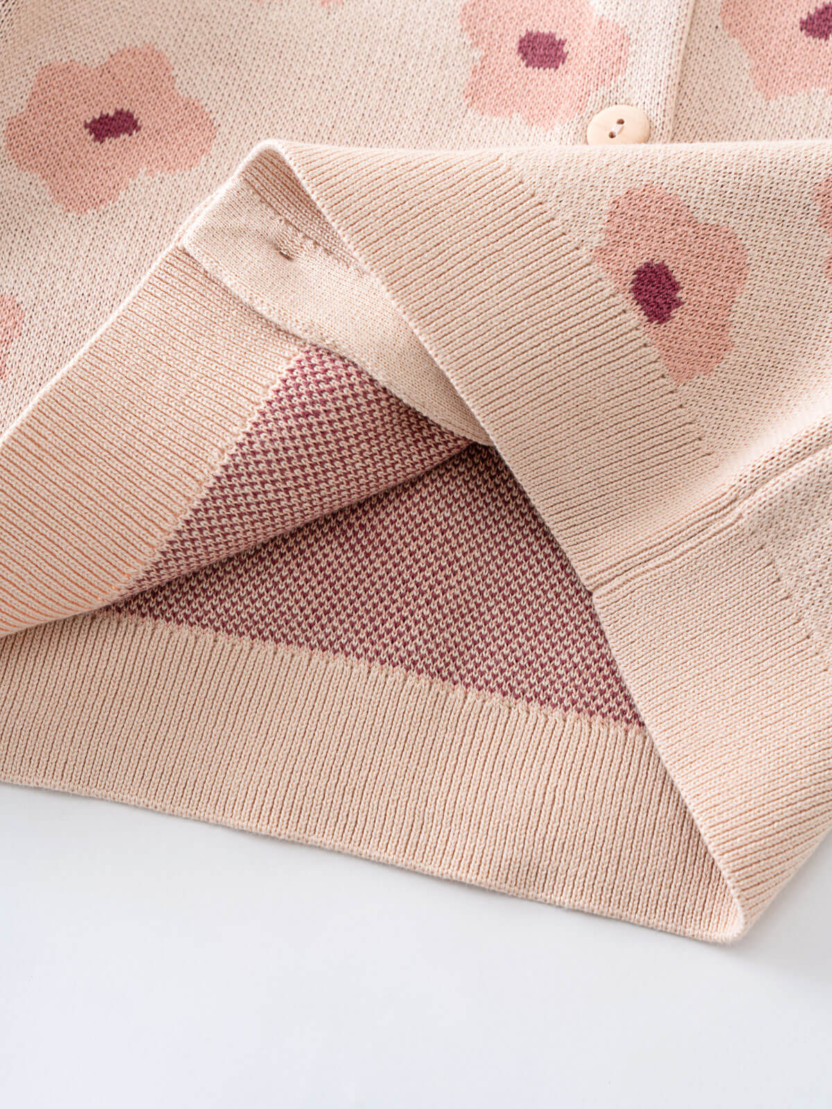 Close-up of a pink knit cardigan with floral patterns on a light background Printed Cardigan - Bold Daisy Girls