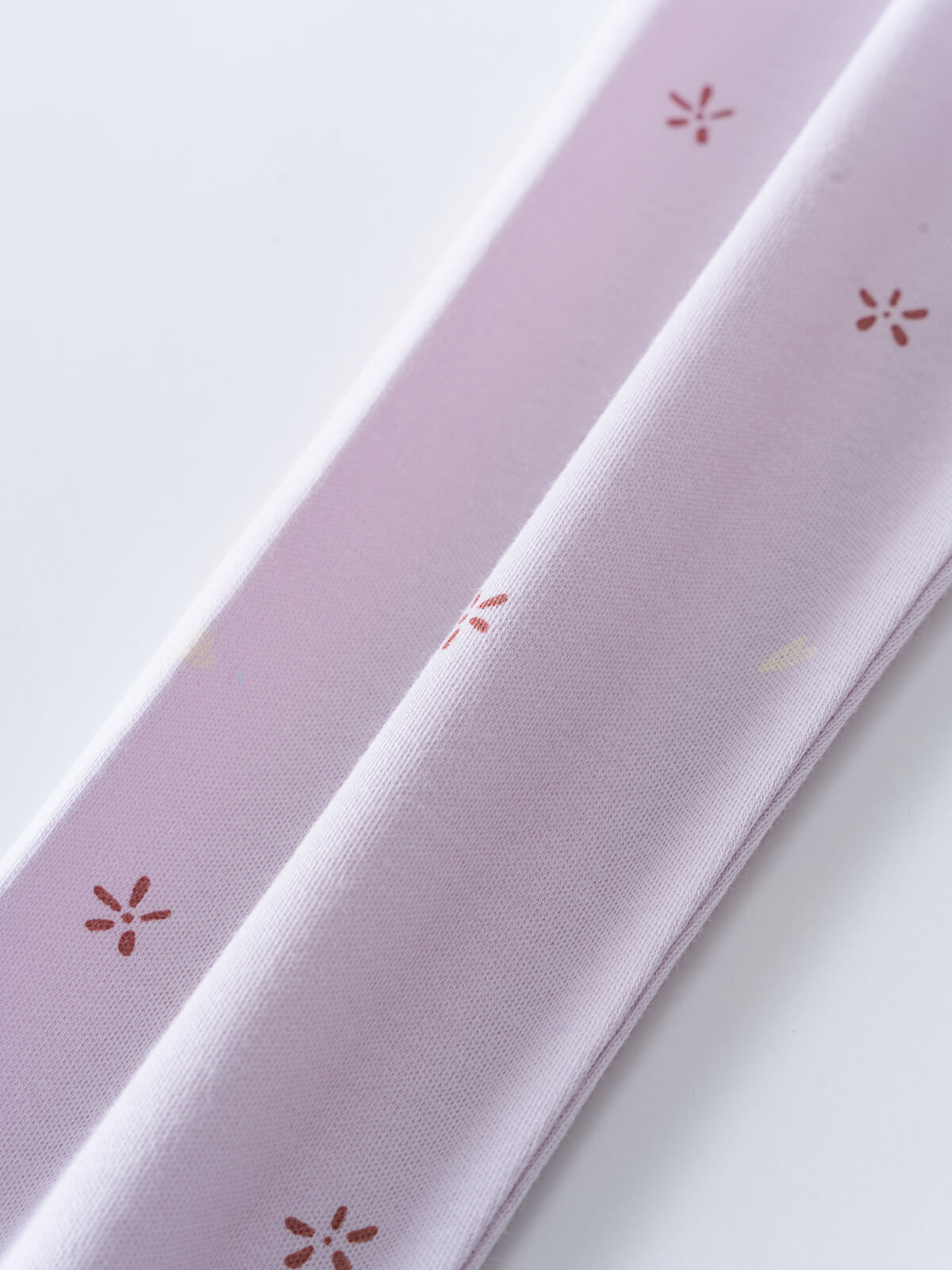 Close-up of pale purple fabric with small rust-colored floral embroidery details printed Leggings - Spring Love Girls
