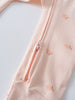 Close-up of a peach-colored baby garment with apple print and zipper detail Printed Long Sleeve One Piece - Apples Baby girl