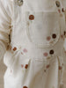 Close-up of cream corduroy overalls with floral embroidery on pocket Printed Overalls - Autumn Bouquet Ecru Baby girl