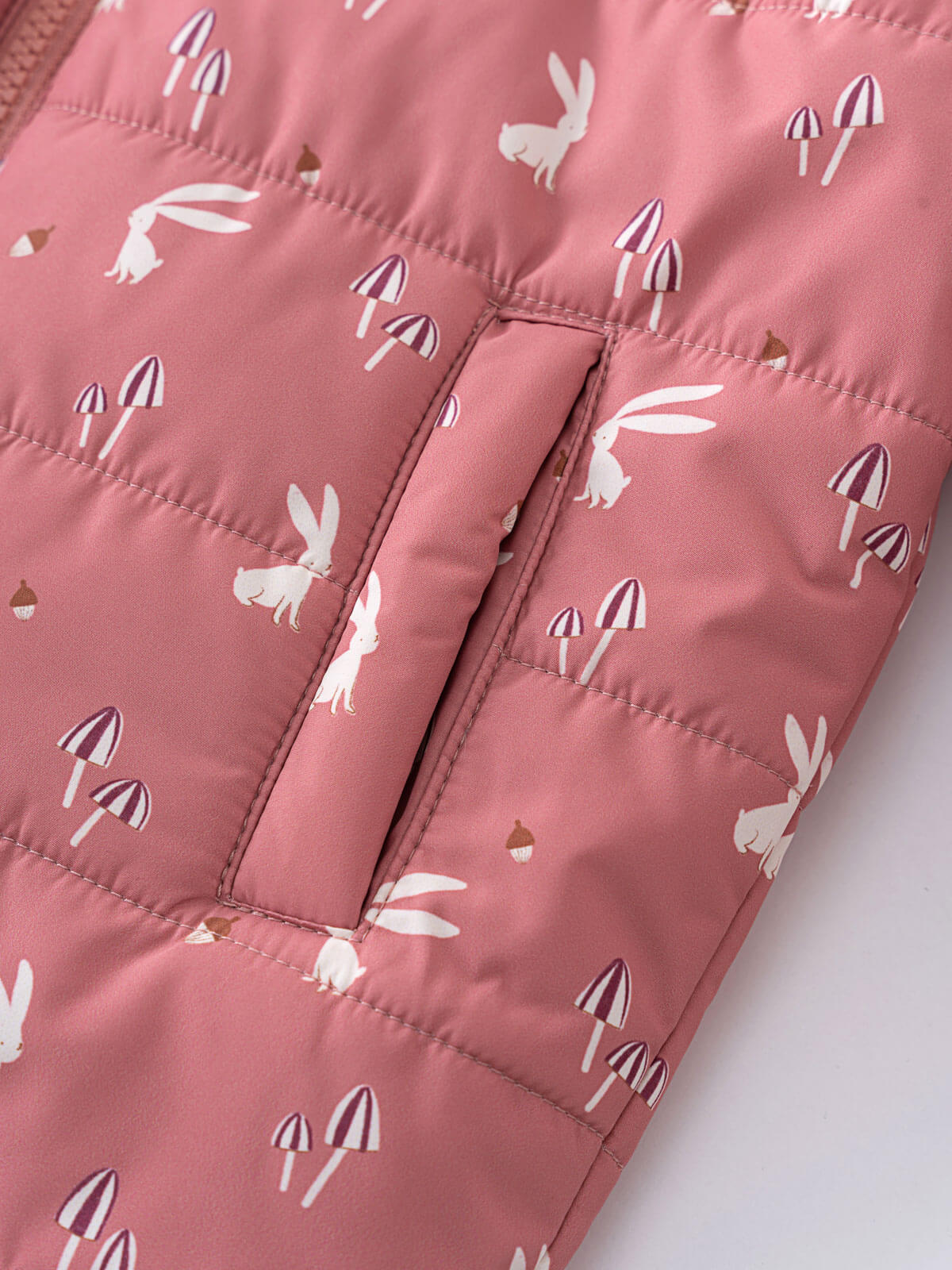 Close-up of pink puffer vest with white rabbits and mushroom print Printed Puffer Vest Jacket - Forest Gathering Rosehip Girls