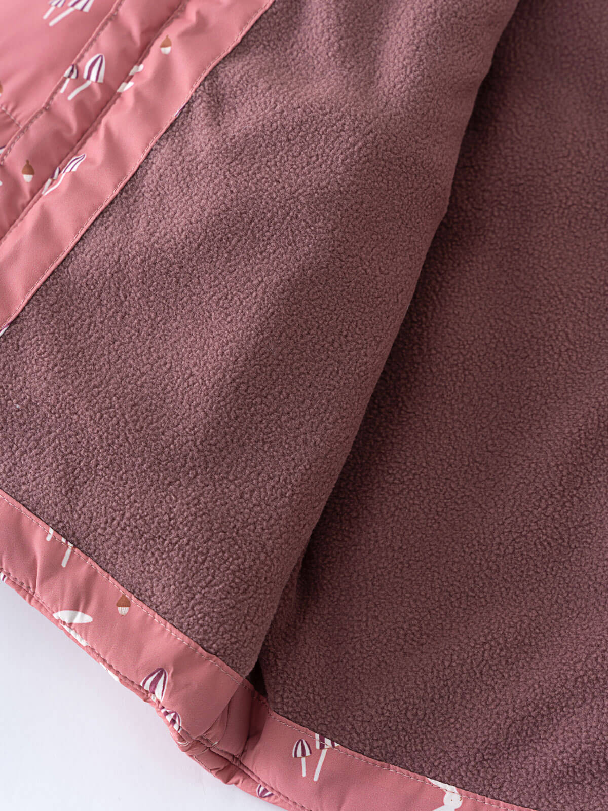 Close-up of pink patterned fabric trim on dusty rose textured material Printed Puffer Vest Jacket - Forest Gathering Rosehip Girls