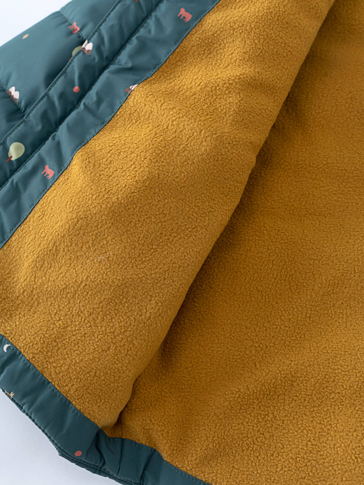 Close-up of mustard fleece lining inside a teal printed puffer vest Printed Puffer Vest Jacket - Mountain View Balsam Boys