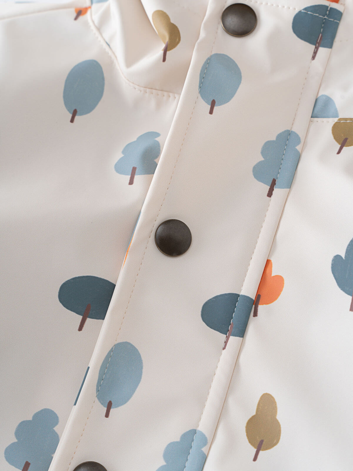 Close-up of white fabric with blue and orange tree print and snap buttons Printed Raincoat - Forest Adventure Ecru Boys