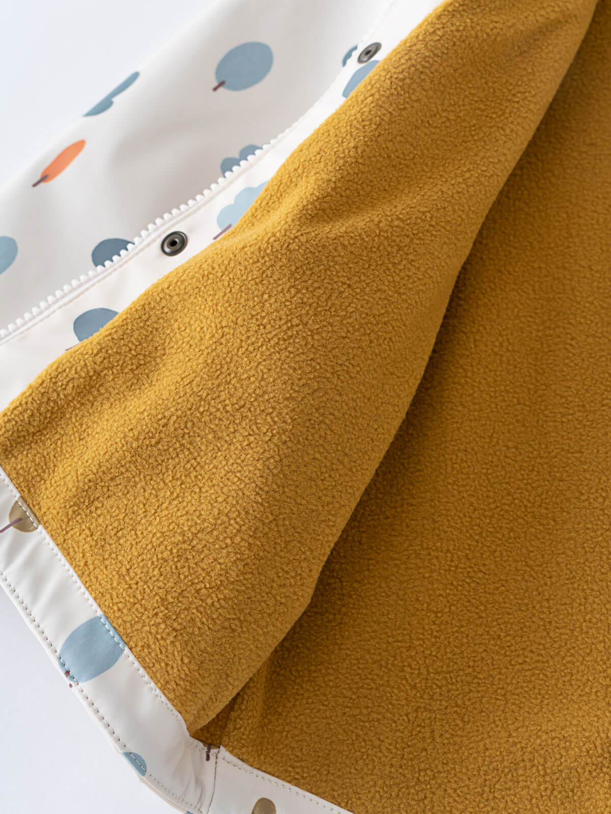 Mustard yellow fleece blanket next to printed white raincoat with zipper detail Printed Raincoat - Forest Adventure Ecru Boys