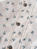 Close-up of fabric with floral print and dark buttons on placket Printed Raincoat - Wild Flowers Ecru Girls