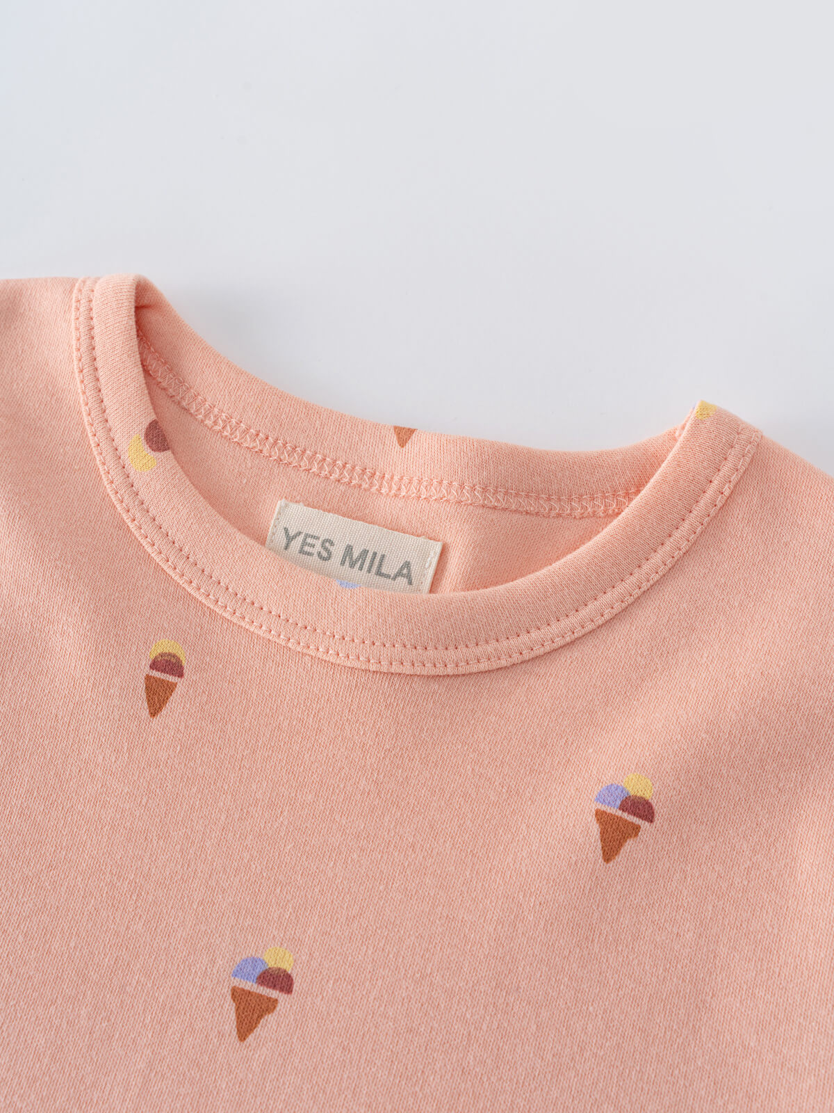 Close-up of a peach-colored t-shirt collar with small ice cream cone prints Printed Short Sleeve Tee Shirt - Ice Creams Girls