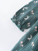 Green dress fabric with rabbit and mushroom pattern on a white background