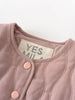 Close-up of a baby outfit with pink buttons and a visible label on a white background Quilted Jacket - Blush Baby girl