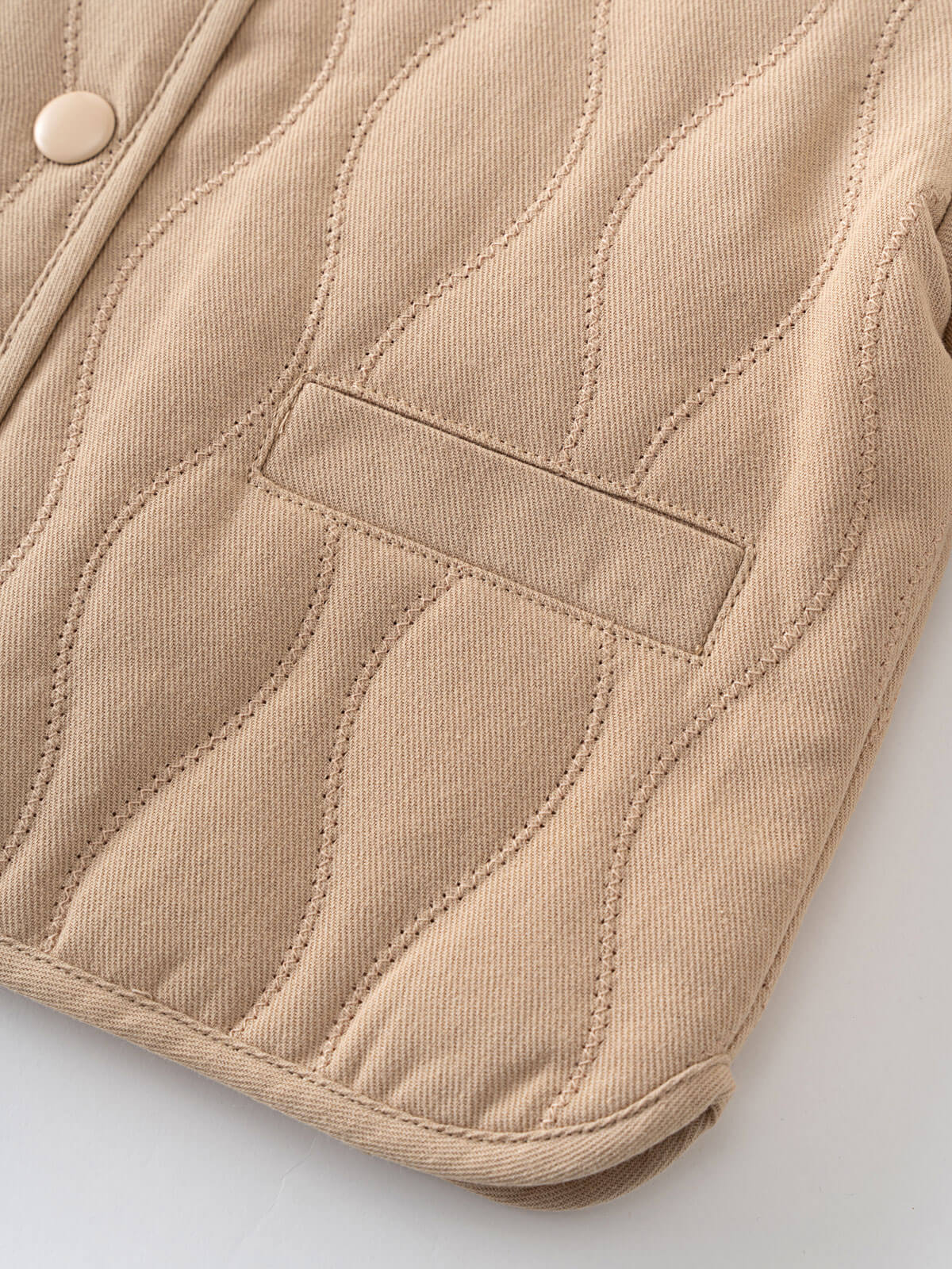 Close-up of a beige quilted jacket on a light gray background Quilted Jacket - Clay Baby girl
