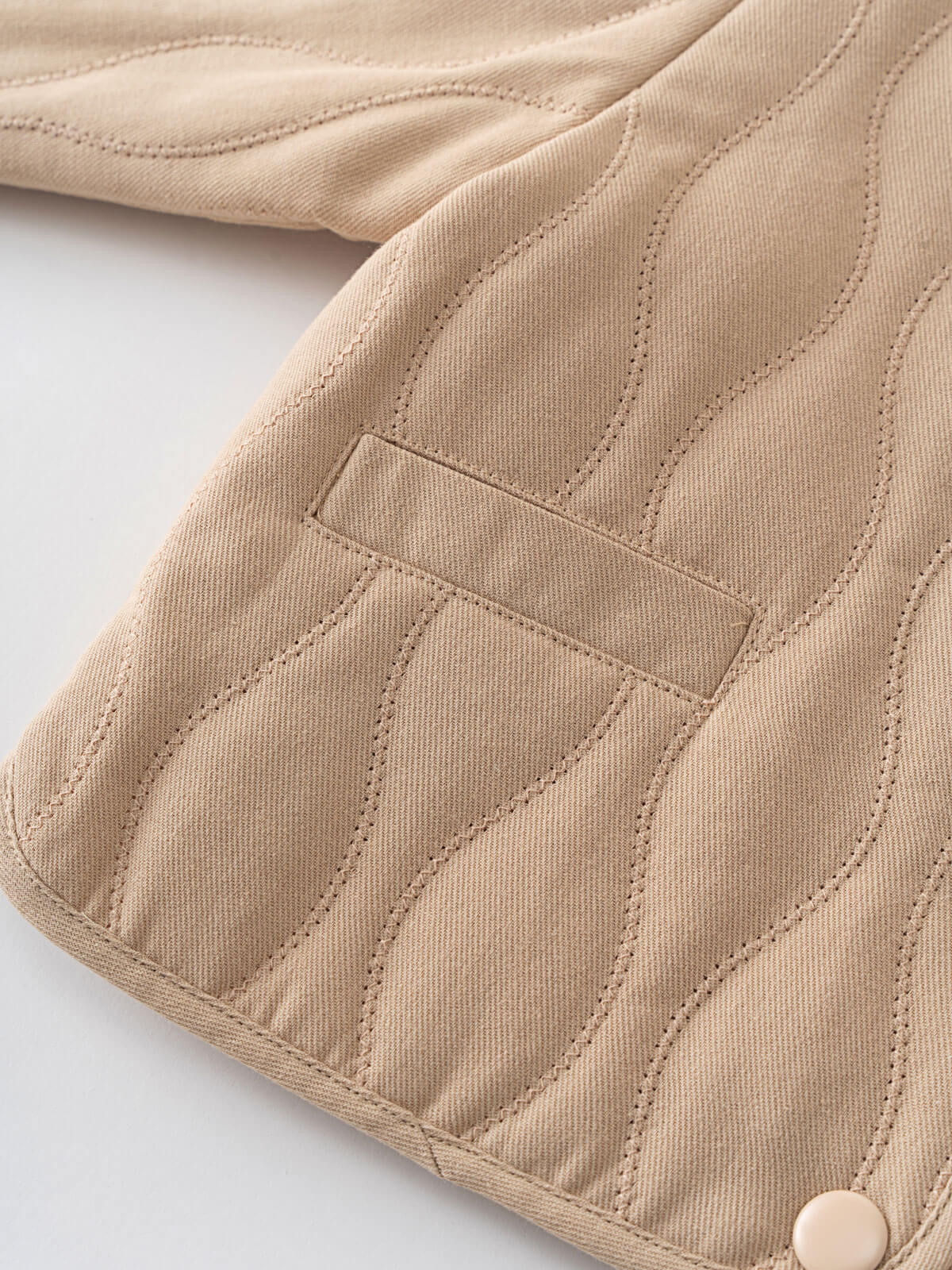 Close-up of a beige quilted jacket on a light gray background Quilted Jacket - Clay Baby girl