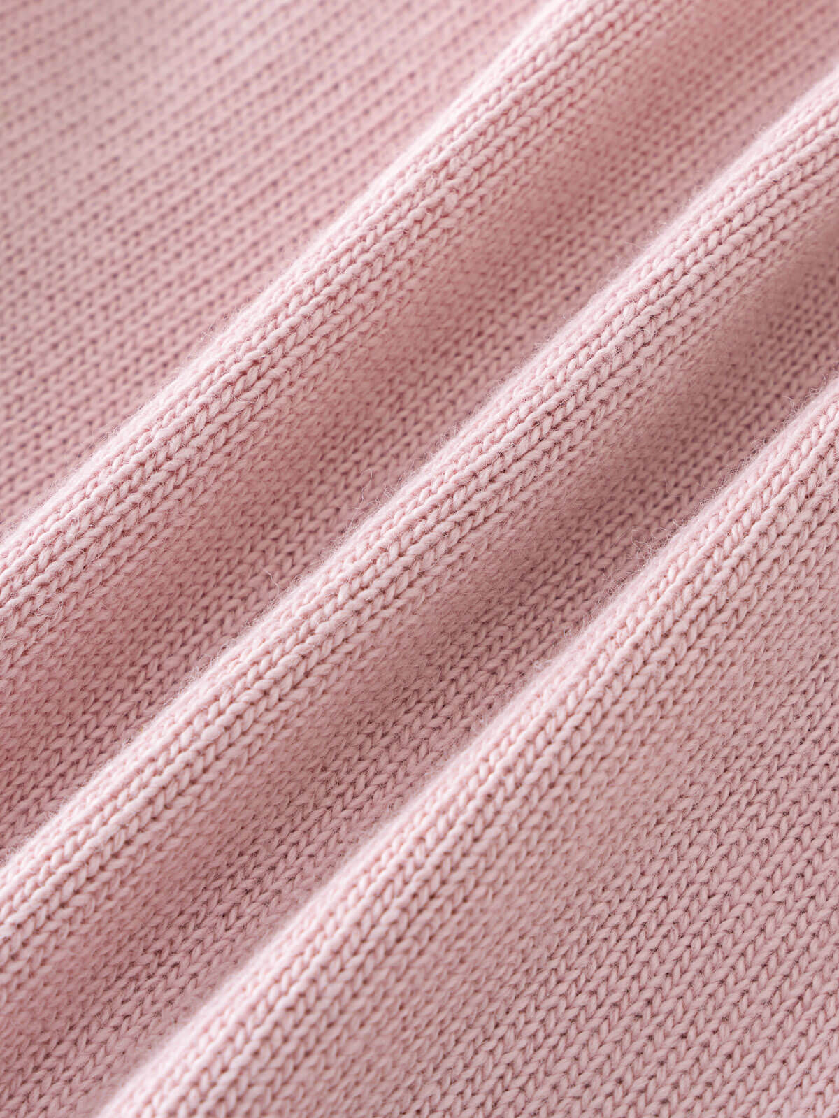 Close-up of pink knitted fabric with ribbed texture and folds Ruffle Cardigan - Blush Girls
