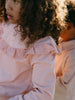 Young girl with curly hair wearing a pink eyelet ruffle collar top Ruffle Top - Mallow Girls