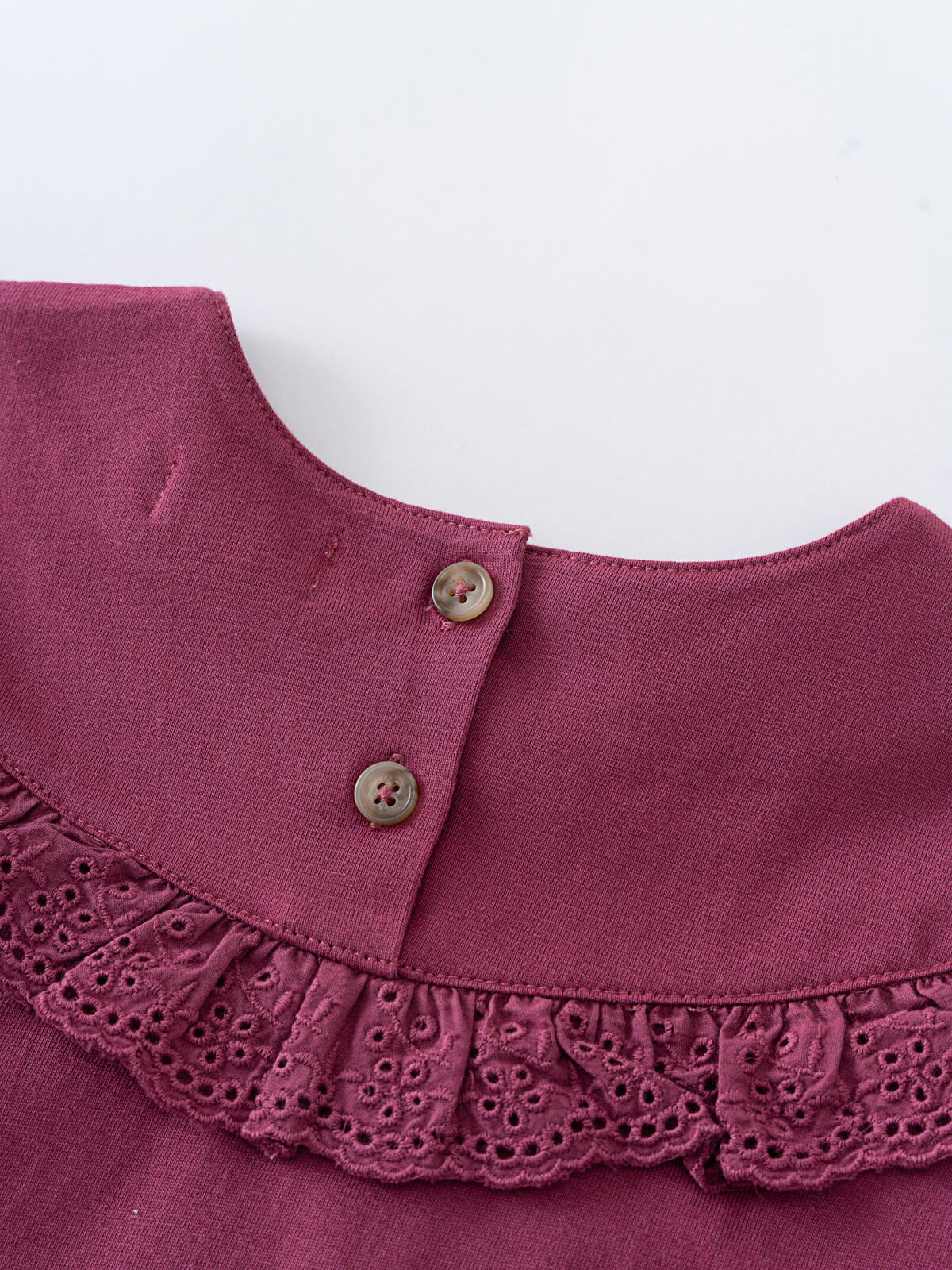Close-up of a purple collar with buttons on a white background Ruffle Top - Plum Jam Girls