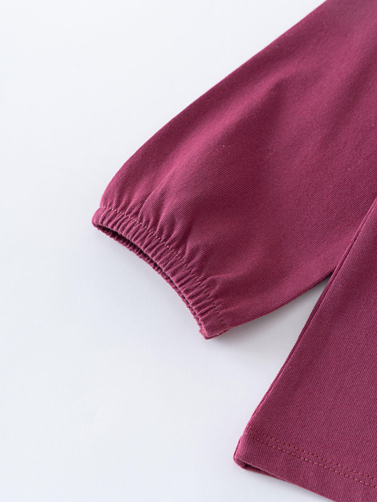 Close-up of a maroon fabric with a white background Ruffle Top - Plum Jam Girls