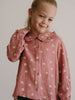 Young girl wearing a pink patterned button-up blouse with ruffled collar Ruffle Woven Blouse - Bird And Blossom Rosehip Girls