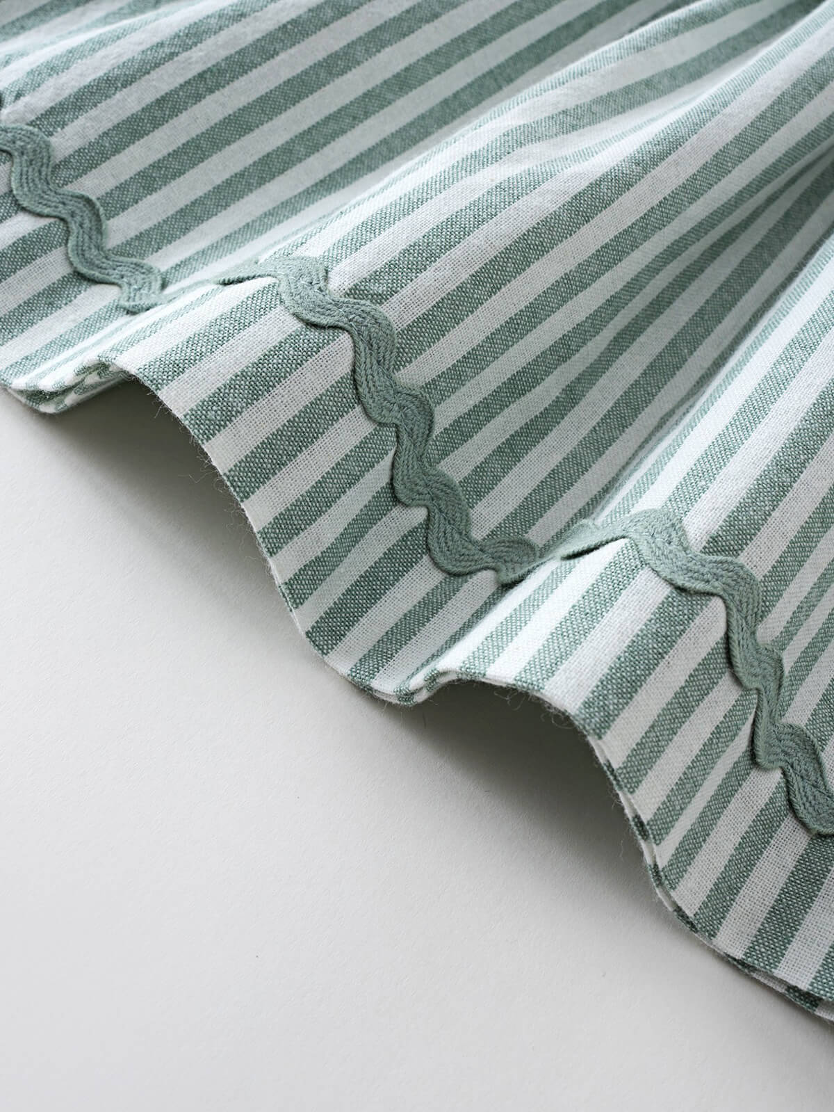 Close-up of green and white striped fabric with gathered ruffle detail shirred Top - Mint Stripe Girls