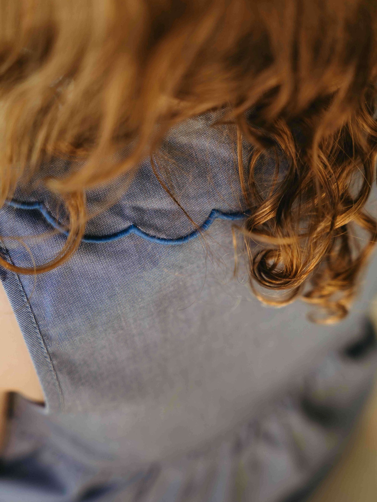 Close-up of a girl wearing a denim dress with a blurred background