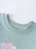 Close-up of a mint green sweatshirt neckline with floral detail below Sophie Sweatshirt - Posy Mint Girls