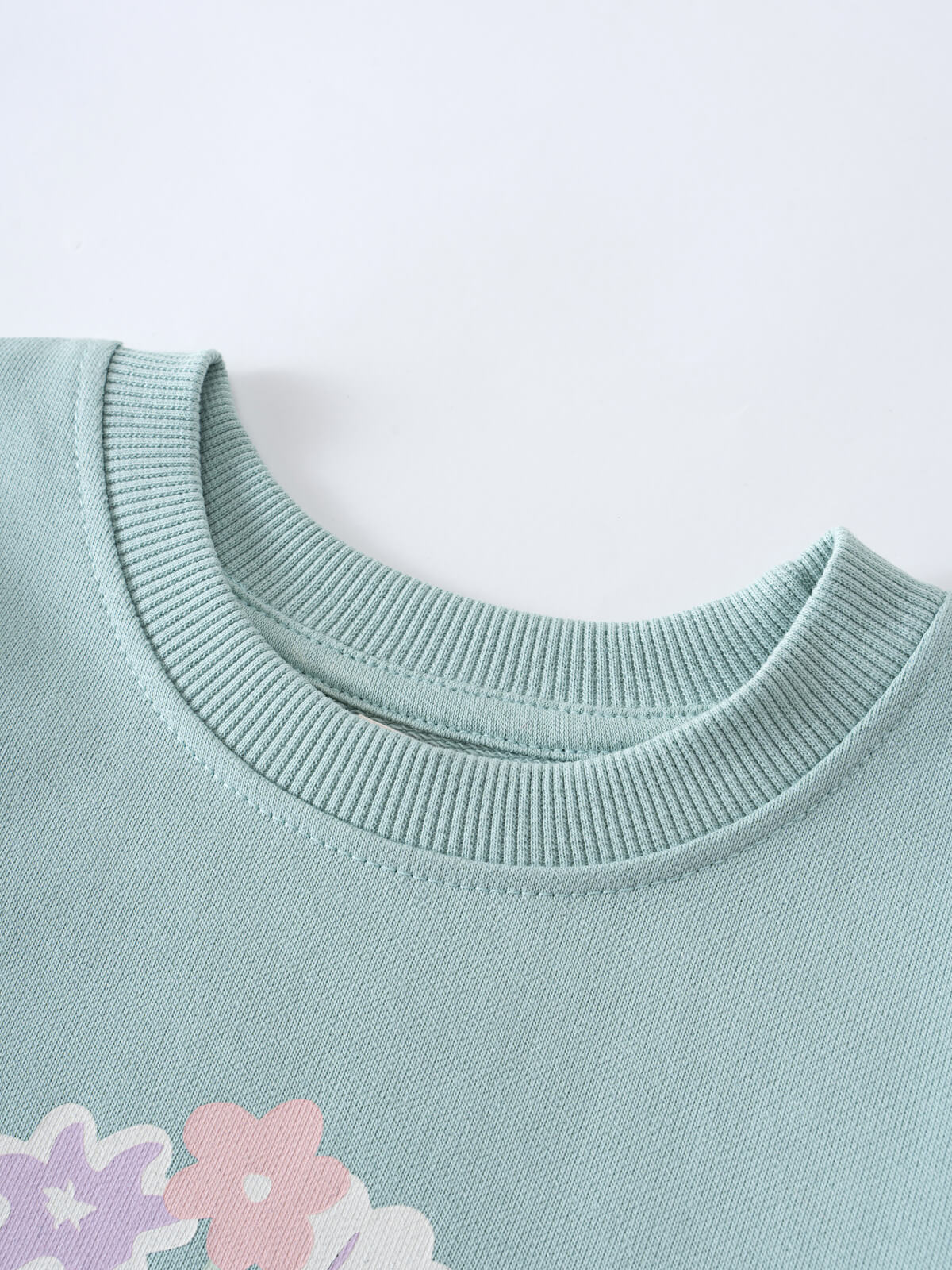 Close-up of a mint green sweatshirt neckline with floral detail below Sophie Sweatshirt - Posy Mint Girls