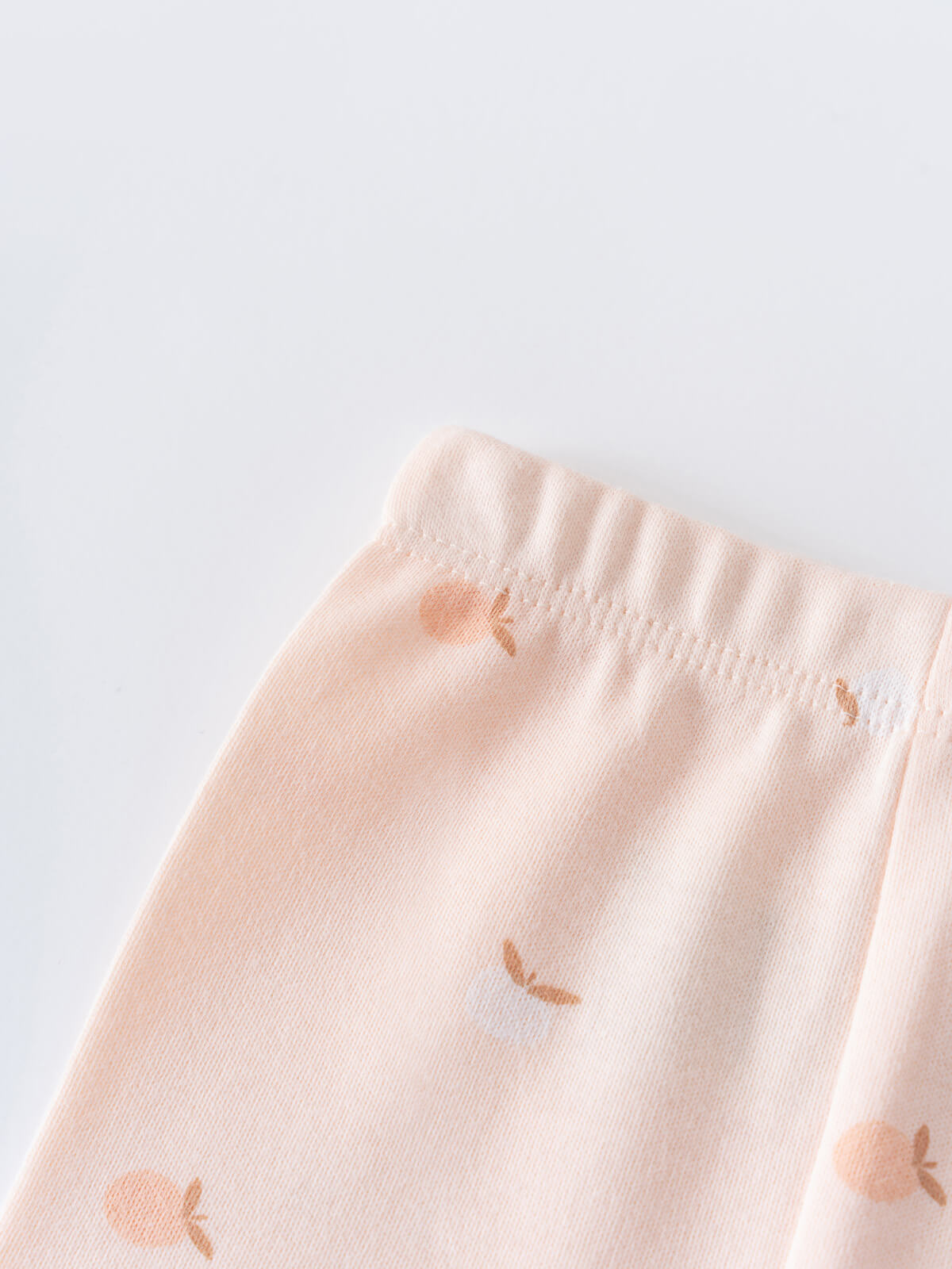 Close-up of pale pink fabric with small apple print pattern Stella Leggings - Apples Baby girl
