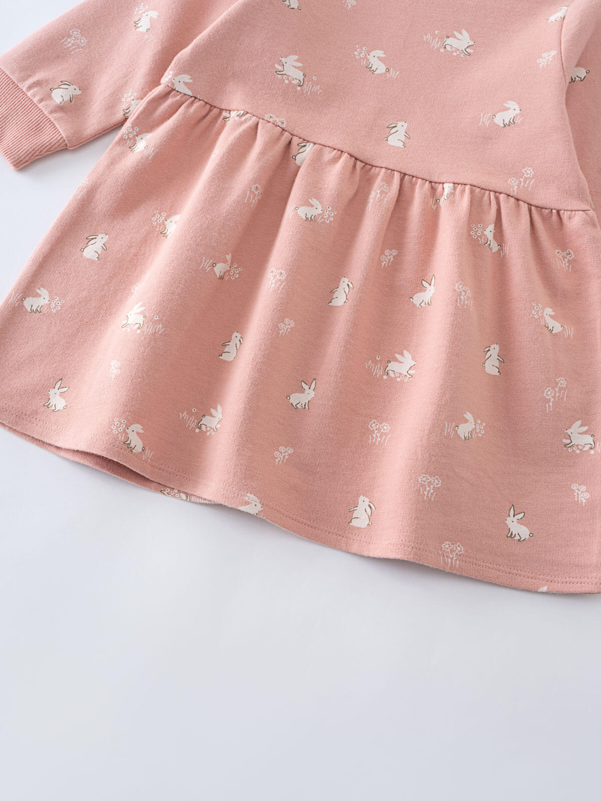 Close-up of pink fabric with white bunny pattern and gathered skirt detail Baby Sweatshirt Dress - Meadow Friends Blush Baby girl