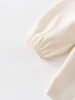 Close-up of a cream-colored blouse with a gathered waist on a light gray background Three Button Blouse - Ecru Girls