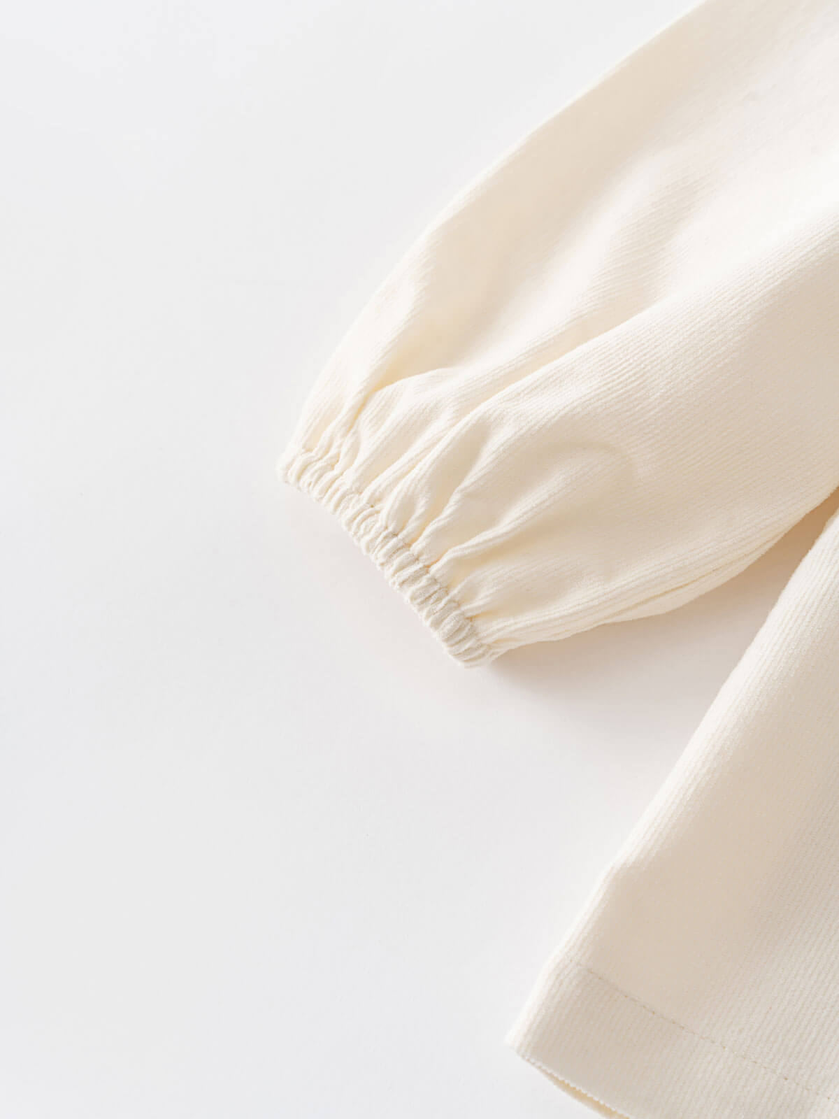 Close-up of a cream-colored blouse with a gathered waist on a light gray background Three Button Blouse - Ecru Girls