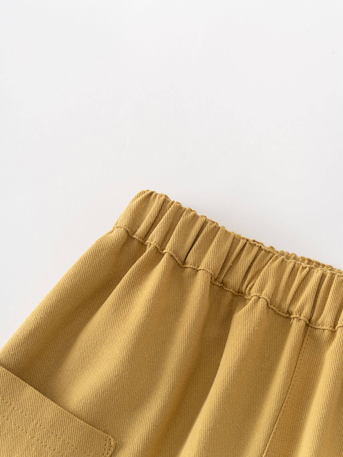 Close-up of mustard yellow pants with an elastic waistband on a light gray background Twill Pants - Golden Pear Boys