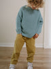 Child wearing light blue knitted sweater and mustard yellow pants indoors Twill Pants - Golden Pear Boys